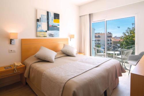 ein Hotelzimmer mit Bett und Balkon in der Unterkunft Hotel Capricho in Cala Ratjada