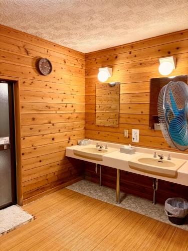 a bathroom with two sinks and a fan at Yabukiso in Yamanakako