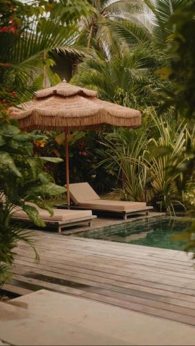 a large straw umbrella sitting next to a pool at Kamaya - Private Villa with Pool in General Luna