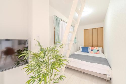 a bedroom with a bed and a potted plant at Mary's Room Hakata in Sumiyoshi