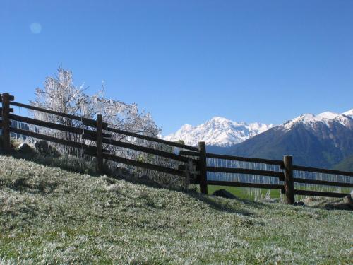 a fence on a hill with mountains in the background at Vital Hotel Ortlerspitz in San Valentino alla Muta