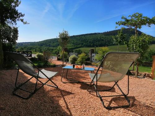 two chairs and a table on a gravel patio at La Bauderie in Bussières