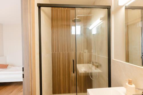 a glass shower in a bathroom with a sink at Pensiunea Mario in Beiuş