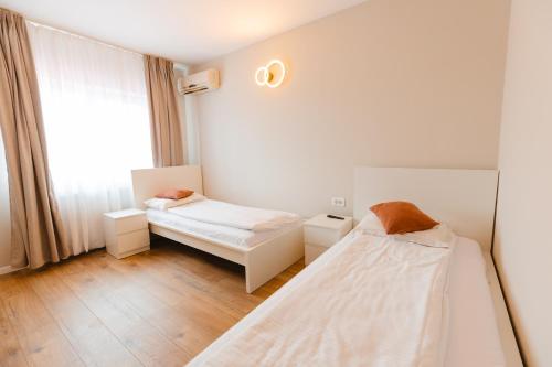 two beds in a room with a window at Pensiunea Mario in Beiuş