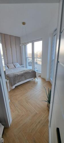 a bedroom with a bed and a large window at Wschód Słońca Ełk in Ełk