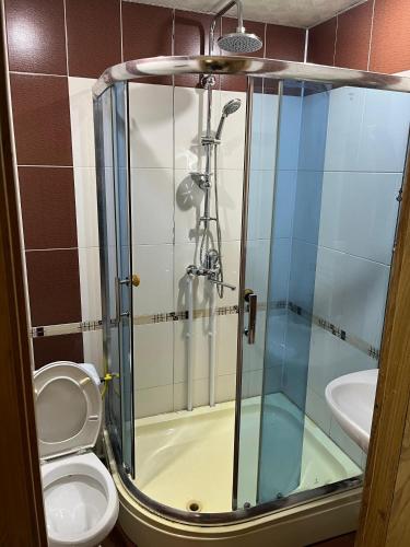 a bathroom with a toilet and a glass shower at Rahat Ev in Ganja