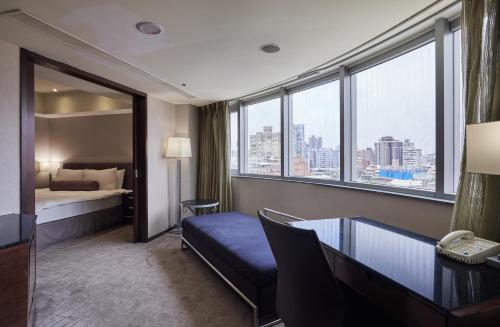a hotel room with a bed and a desk and window at K Hotel - Yunghe in Yonghe
