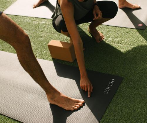 Eine Frau in einem Yogakurs, die Füße auf einer Matte. in der Unterkunft Hotel Helios Lloret in Lloret de Mar