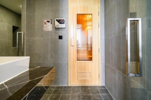 a bathroom with a wooden door next to a sink at Beachfront 1BDR Condo (PE24) in Na Jomtien