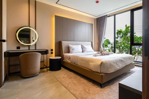 a bedroom with a bed and a desk and a mirror at Beachfront 1BDR Condo (PE24) in Na Jomtien
