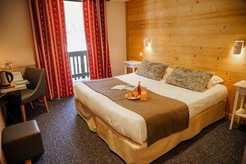 a hotel room with a bed with a tray of fruit on it at Hotel Le Faranchin in Villar-dʼArène