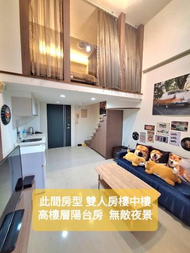 a living room with a blue couch and a kitchen at Capybara樓中樓湯屋 in Jiaoxi