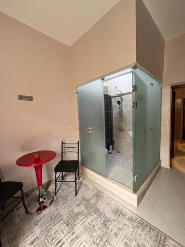 a glass shower in a room with a table and chair at Castle hostel in Cairo