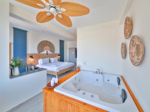 a large bath tub in a room with a bed at Kas Athena Hotel in Kaş