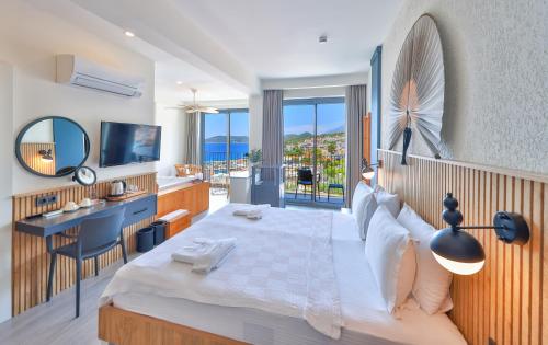 a bedroom with a bed and a desk and a television at Kas Athena Hotel in Kaş