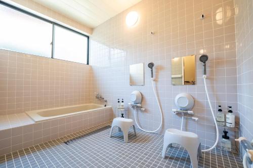 a bathroom with a tub and a toilet and a sink at Oceanfront Up to 14 Guests BBQ Available オーシャンフロント小浜田烏 in Obama