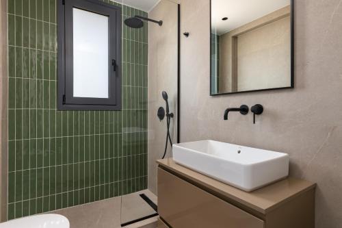 a bathroom with a sink and a mirror at Palmeral Luxury Villas in Kremasti