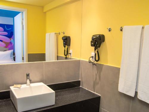 a bathroom with a sink and a mirror at Ibis Styles Garanhuns in Garanhuns