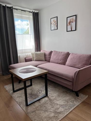 a living room with a purple couch and a coffee table at Apartament Mirka centrum in Lidzbark Warmiński