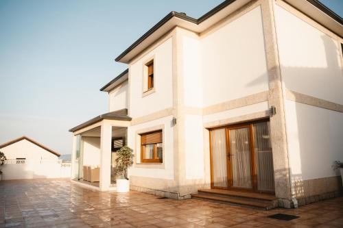 a white house with a courtyard at Villa Montalvo Beach-Piscina climatizada in Montalvo
