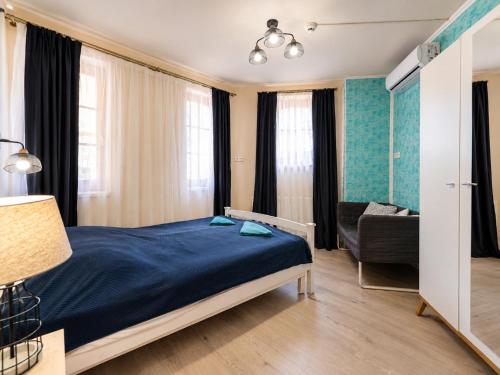 a bedroom with a blue bed and a couch at Marina Panzio in Siófok