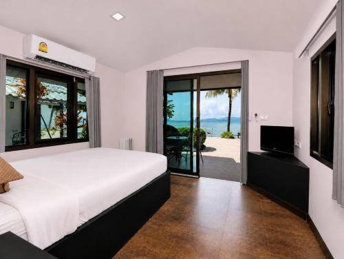 a bedroom with a bed and a view of the ocean at Phangan Beach Resort in Ban Tai