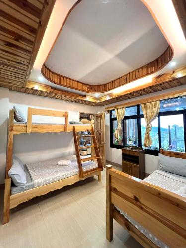 two bunk beds in a room with windows at Carpenters homestay in Sagada