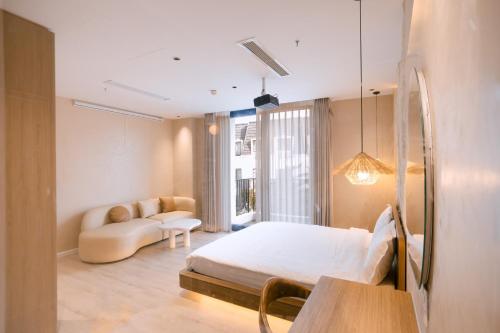a bedroom with a bed and a couch and a mirror at UMEE Homestay in Thôn Trường Giang