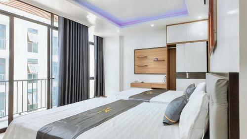 a bedroom with a large bed and large windows at Phượng Sơn Hotell in Sầm Sơn