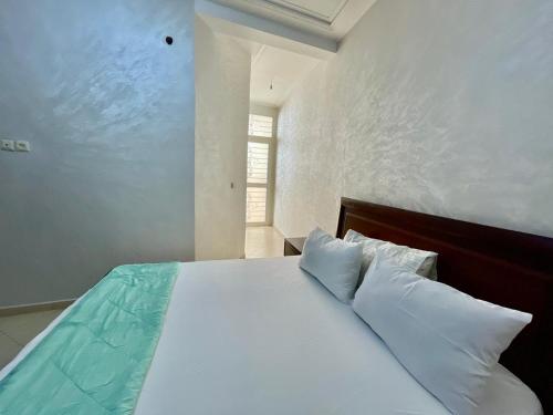 a bedroom with a bed with white sheets and pillows at luxury apartment in fez in Fez