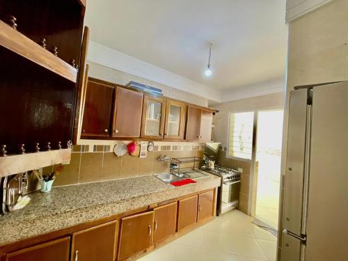 a kitchen with brown cabinets and a sink and a refrigerator at luxury apartment in fez in Fez