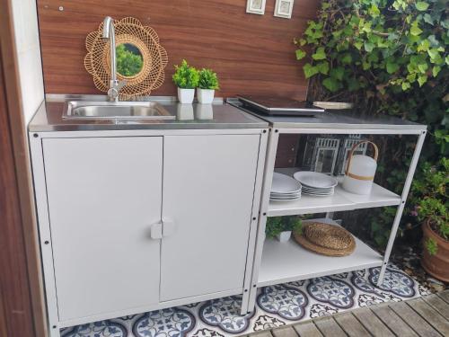 a kitchen counter with a sink and dishes at Apartamento con jardín in Barro de Llanes