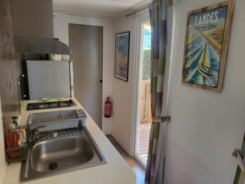 a kitchen with a sink and a stove and a window at Ocean Lodge Messanges in Messanges