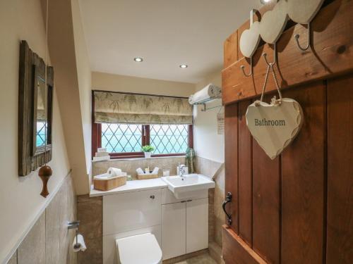 a bathroom with a toilet and a sink at Barclay Cottage in Ashford
