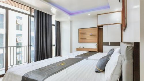 a bedroom with a large bed and large windows at Phượng Sơn Hotell in Sầm Sơn
