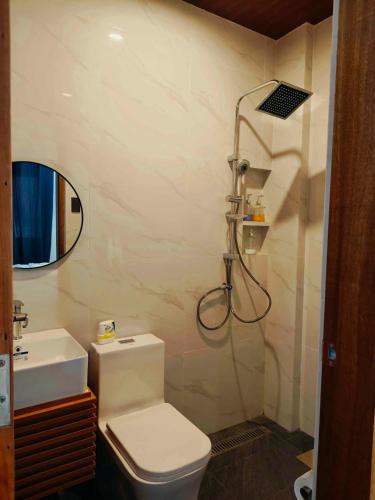 a bathroom with a shower and a toilet and a sink at The Annwin Hotel - Sablayan in Sablayan