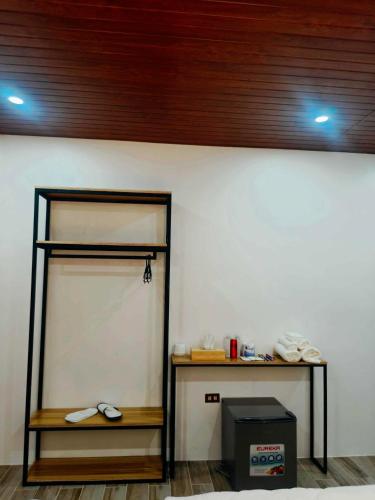 a room with a wall with a shelf and a table at The Annwin Hotel - Sablayan in Sablayan