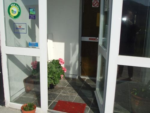 an entrance to a building with a door and potted plants at Achill West Coast House in Dooagh