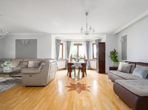a living room with a couch and a table at Golden Villas Garden Retreat - Private Garden & BBQ in Kobyłka