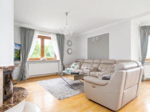 a white living room with a couch and a table at Golden Villas Garden Retreat - Private Garden & BBQ in Kobyłka