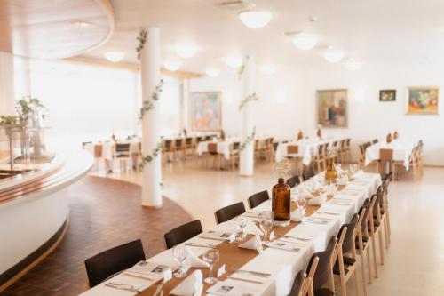a dining room with white tables and chairs at Majoitus Fox in Kuopio