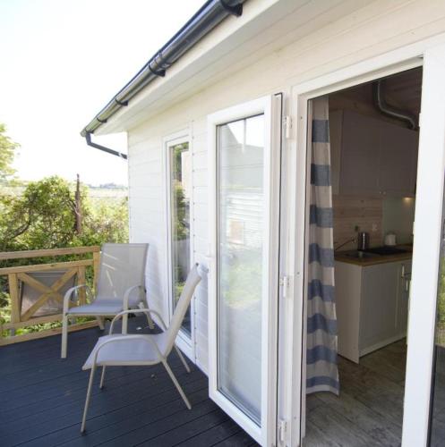 a patio with a table and chairs on a deck at Domek wakacyjny Bloom in Rewa
