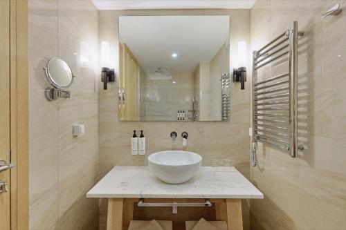 a bathroom with a bowl sink and a mirror at Crowne Plaza Budva by IHG in Budva