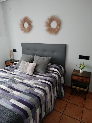 a bedroom with a bed with two mirrors on the wall at Casa Rural La Tejeria in Villora