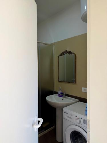 a bathroom with a sink and a washing machine at Il Sol Apartment in Lezhë
