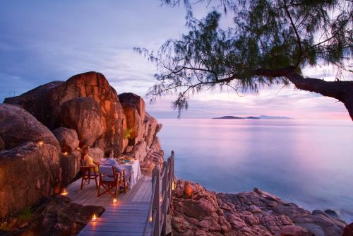 a view from a balcony overlooking a body of water at Constance Lemuria in Grand'Anse Praslin