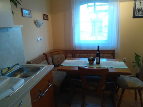 a kitchen with a table with a bottle of wine on it at Apartments and Rooms With View on Bled in Bled