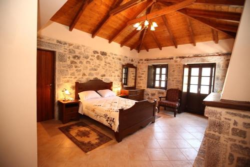 a bedroom with a bed in a room with stone walls at Vasilios Apartments Hotel in Limeni