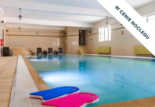 a swimming pool with blue and pink swimming mats in it at Prawdzic Family Resort & Wellness in Gdańsk