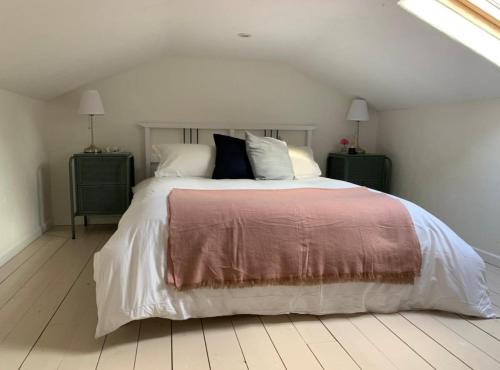 a bedroom with a large bed with white sheets and pillows at 2 bed cottage, in the Wicklow Mountains in Tinahely